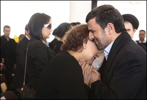 Iran's President Mahmoud Ahmadinejad comforts Elena Frias next to the flag-draped coffin of her son, Venezuela's late President Hugo Chavez, during the funeral ceremony at the military academy in Caracas, Venezuela Friday.