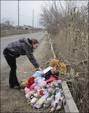 Shannon Whetstone reads notes Monday at the scene where six teens died in a crash early Sunday in Warren, Ohio. Two teenagers survived the crash.