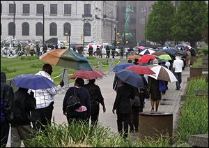 Hundreds of people line up in a downtown Cleveland park to attend a job fair. The Toledo area had an anticipated rise in unemployment after the holidays.