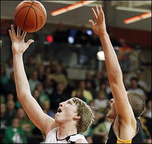 RJ Coil takes a shot against Colonel Crawford's Nate Klingenberger. Coil scored 14 to lead Ottawa Hills.