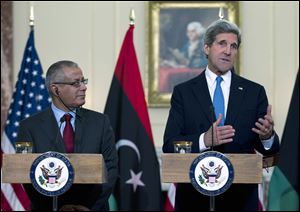 Secretary of State John Kerry, accompanied by Libyan Prime Minister Ali Zeidan gestures as he speaks to reporters during their joint news conference at the State Department in Washington today.