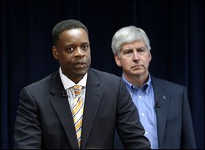 Kevyn Orr, left, speaks as as Michigan  Gov. Rick Snyder listens during a news conference in Detroit.