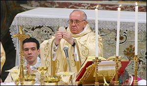 Pope Francis raises the host during Mass with the cardinals in the Sistine Chapel. The Pontiff and all the cardinals wore vestments of gold, signifying joy. 