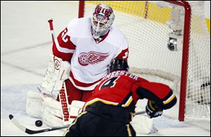 Detroit Red Wings goalie Jonas Gustavsson lets in a goal by Calgary Flames' Jay Bouwmeester.