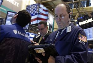 Trader Gordon Charlop, right, works on the floor of the New York Stock Exchange. World stock markets shared Wall Street's ebullience and turned higher Thursday March 14, 2013 ahead of the release of U.S. jobless claims.