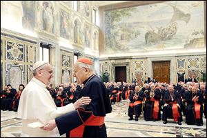 Pope Francis is greeted by Cardinal Angelo Sodano, dean of the College of Cardinals, as he meets the cardinals Friday for the first time after his election this week. Francis, elected by the college on Wednesday, continued to disarm the cardinals and others with his impromptu style and his humility.