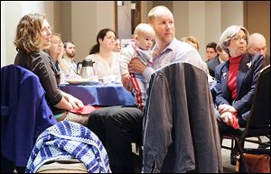 Sian McHale, left, and husband, Aaron, holding 4-month-old son Silas, listen to speakers during the Greater Toledo Right to Life fifth annual Legislative Briefing Breakfast at The Premier banquet hall in Toledo.