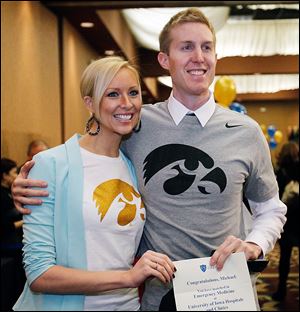 Anna Haarstad, 28, left, and her husband, Michael, 31, show off their Hawkeye T-shirts in celebration of his acceptance to his first-choice residency, emergency medicine at the University of Iowa. 