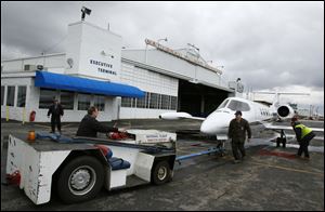 Todd Smolinski pulls a plane out of the hangar at National Flight Services in Swanton.  Business at National Flight Services has decreased by 25 percent to 30 percent since 2003, but things are looking up.