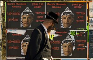 An Ultra Orthodox Jewish man walks past posters depicting US President Barack Obama wearing a traditional Arab headdress, in Jerusalem in 2009.