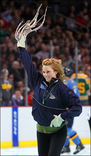 Walleye ice crew member Kate Schmoekel smiles as she waves an octopus thrown on the ice after the Walleye scored against the Wheeling Nailers in the first period.
