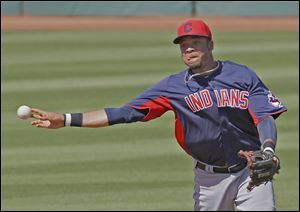 The Indians’ Juan Diaz throws  out the Reds' Jason Donald from short in the third inning of Sunday’s exhibition game. The two teams ended the game tied at 7 after nine innings.