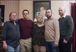 John Schroeder, left, Shawn Schroeder, Sandra Schroeder, Christopher Schroeder, and his partner, Adrian Lilly, pose in front of a painted portrait of Matthew Schroeder, who died of a heroin overdose at his bedroom desk in the Old West End. John and Sandra are Matthew's parents, and Shawn and Christopher are brothers.   