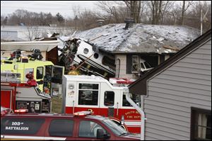 The front end of a Hawker Beachcraft Premier jet sits in a room of a home on Iowa Street in South Bend, Ind., Sunday. Authorities say a private jet apparently experiencing mechanical trouble crashed resulting in injuries. 