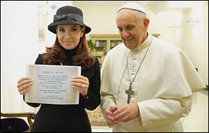 Pope Francis poses Monday at the Vatican with Argentine President Cristina Fernandez, who holds a photo of a plaque marking a treaty between Argentina and Chile. The Pontiff had denounced Ms. Fernandez’s policies on contraception and gay marriage.