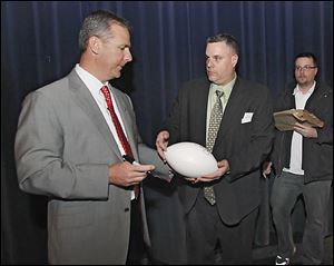 OSU coach Urban Meyer signs a football for Mike Birmingham on Monday during his visit to the Stranahan Theater.