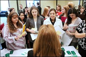 BIZ jobfair21p University of Toledo nursing student Marisela Lemus, center right, poses a question to ProMedica human resources specialist Sharon Dachenhaus Wednesday afternoon during the University of Toledo's job fair for nursing students at the Hotel on the university's Health Science Campus in South Toledo. This was the 13 the university had solely hosted the job fair Featuring 26 vendors, organizers said they were expecting more than 100 recent and upcoming graduates from the University of Toledo, Bowling Green and other programs in the area to attend.   THE BLADE/KATIE RAUSCH