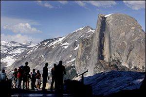 Visitors view Half Dome from Glacier Point at Yosemite National Park. Permits and lodging in the national parks go fast. People who leave planning to the last minute will find slim pickings.