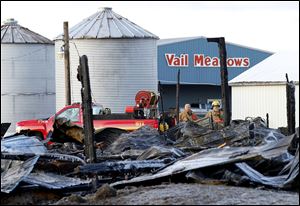 Oregon firefighters remain on the scene after an early morning barn fire at the Vail Meadow Equestrian Center on Cedar Point Road in Oregon, Thursday, March 21, 2013.  10 horses and some other animals were killed in the fire. 