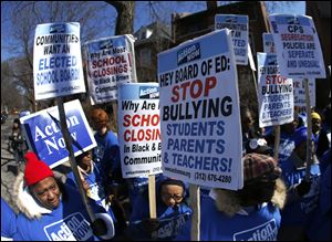 Parents protest outside the home of Chicago's Board of Education President David Vitale’s house Thursda. Teachers say the city of Chicago has begun informing teachers, principals and local officials about which public schools it intends to close under a contentious plan that opponents say will disproportionately affect minority students in the nation's third largest school district. 