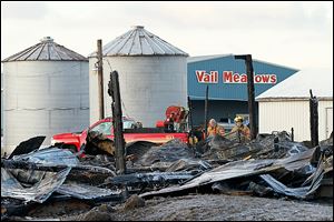 Firefighters remain on the scene after an early morning barn fire at the Vail Meadows Equestrian Center on Cedar Point Road in Oregon on Thursday.