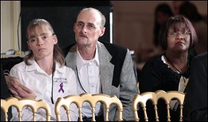Kirk Smalley, center, and his wife Laura, left, of Perkins, Okla., and Sirdeaner Walker from Springfield, Mass., listen at the Conference on Bullying Prevention in this 2001 file photo in the East Room of the White House in Washington.