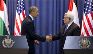 President Barack Obama and Palestinian President Mahmoud Abbas shake hands during a joint news conference at the Muqata Presidential Compound, in the West Bank town of Ramallah, today.