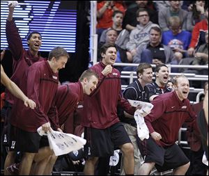 Harvard players celebrate on the bench after beating New Mexico during a second round game in the NCAA college basketball tournament in Salt Lake City Thursday, March 21, 2013. Harvard beat New Mexico 68-62. 