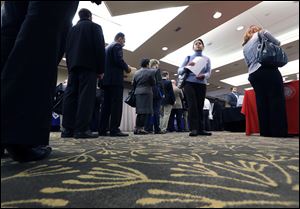 Job seekers line up to speak with a State Dept. employee about job opportunities in the federal government during a job fair.