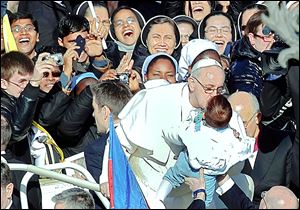 Pope Francis kisses a child in St. Peter's Square at the Vatican. He urged people gathered for his installation last week to protect the weakest and the poorest.