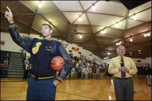 Marc Loving, left, sings the St. John's school song at the end of an assembly honoring him for being named Ohio's Mr. Basketball. At right is basketball coach Ed Heintschel.