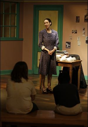 In this Monday, March 18, 2013 photo, actress Julie Mauro portrays Miep Gies, one of Anne Frank’s protectors and the woman who preserved her diary, during a performance in an Anne Frank exhibition at the Indianapolis Children's Museum in Indianapolis. Eleven saplings grown from seeds taken from the massive chestnut tree that stood outside the home in which Frank and her family hid are being distributed to museums, schools, parks and Holocaust remembrance centers through a project led by The Anne Frank Center USA.