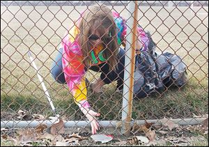 University of Toledo student Amber Froggatt, 21, picks up trash at UT's Carter Field during the Big Event. 
