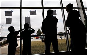 Players and parents check the standings during the 2013 GLCA Scholastic Open chess tournament at Bowling Green Middle School. 