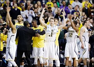 Michigan's Nik Stauskas (11) leads the cheers as the final seconds tick away in the Wolverines' victory over VCU. Michigan will now travel to Texas for a game at Dallas Cowboys stadium.