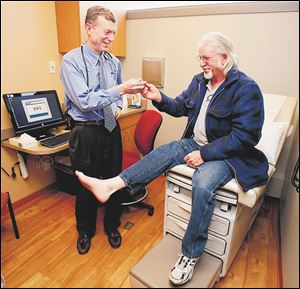 Dr. Mark Burket, UTMC chief cardiologist, examines Keith Bowman of Cincinnati, who has peripheral artery disease.