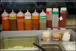 Sauces stand ready for the day's orders at Hot Head Burritos in Perrysburg.