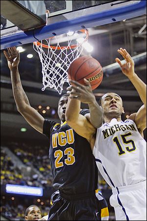 Michigan forward Jon Horford, right, tangles with VCU’s Jarred Guest in Saturday’s game. The Wolverines are 6-1 on neutral courts this season as they head to Dallas to play in Cowboys Stadium.