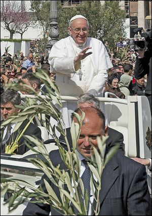 Pope Francis wades through a cheering crowd of some 250,000 pilgrims in  St. Peter's Square on Palm Sunday. The Pontiff encouraged people to be humble and young at heart.