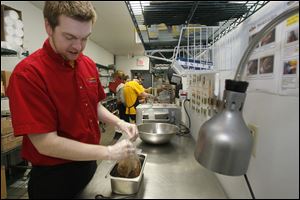 Assistant manager Jacob Hoover, 24, of Bowling Green, gets ready to shred pork, one of the options at the restaurant.