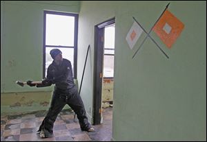 Greenspace worker Nick Gillespie removes door frames in preparation to demolish the Michigan National Guard armory in Monroe.