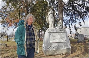 Lisa Swickard, who wrote a book about the flood, stands next to  a monument to the nine Klingshirn children at St. Joseph Cemetery in Tiffin.  Three more family members drowned when the house collapsed.