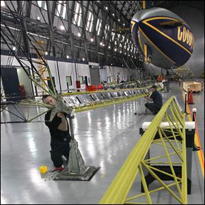 Goodyear airship mechanic Tom Bradley, left and Marcus Draeger, an airship mechanic with the German Zeppelin Corporation, work on a section of the interior frame as construction of the first of the Goodyear Rubber & Tire Company's new fleet of airships, the Goodyear NT, begins at the Wingfoot Lake hangar.