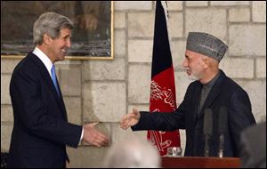 Secretary of State John Kerry reaches to shakes hands with Afghan President Hamid Karzai at the end of their joint news conference at the Presidential Palace in Kabul.