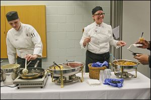 Culinary student Maria Lay, left, cooks pancakes as instructor chef Gretchen Fayerweather, right, talks with a student during Hunger Awareness Day at Owens Community College in Perrysburg Township. Cooking demonstrations are also held on Tuesdays when the food pantry is open for students. 