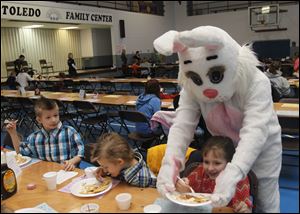 Robbie Moore, left, watches the Easter Bunny take Abby Moore's plate during the pancake breakfast.
