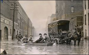 Floods that swept through Ohio in March, 1913, caused millions of dollars in damage and took hundreds of lives. While Toledo escaped major damage, boats, such as the one above on Water Street looking south from near Adams Street, were used for what rescue work was needed. This photo first ran in The Blade on March 26. 1913.