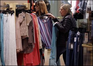 In this March 5, 2013 photo, shoppers look at clothing on sale at the Footloose store in Mt. Lebanon, Pa. The Conference Board, a New York-based private research group, said its reading of consumer confidence fell in March after rebounding last month. The index gauges how Americans are feeling about their jobs, incomes and other bread-and-butter issues. That's important because consumer spending accounts for 70 percent of U.S. economic activity. (AP Photo/Gene J. Puskar)