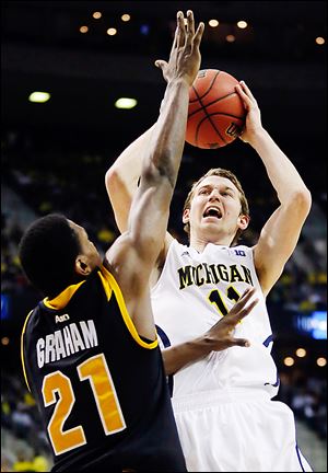 Michigan guard Nik Stauskas shoots over VCU's Treveon Graham during the Wolverines' 78-53 win Sunday. They play top-seeded Kansas in the Sweet 16 on Friday night.