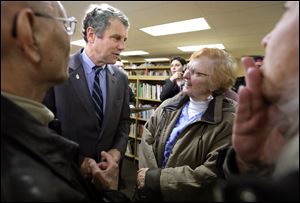 U.S. Sen. Sherrod Brown speaks with Diane Pretzer, Bowling Green, right, and others at Grounds for Thought in Bowling Green.